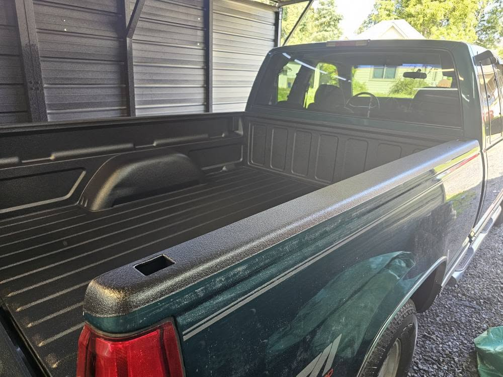Coated bed of a green pickup truck